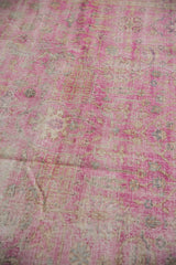 Angled detail of the vintage distressed Sivas rug's hot pink fuchsia pile and exposed foundation.