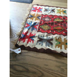Colorful star-like geometric motifs and natural fringed edge of a vintage Turkish Kilim.
