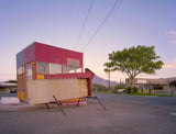 Joe Farrell's photograph of a red roadside kiosk with a broken arrow sign in New Mexico.