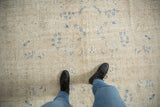 Distressed Sivas carpet featuring worn ivory tones and scattered cobalt blue floral motifs.
