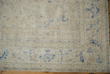 Distressed vintage Sivas carpet, worn ivory pile revealing foundation, with cobalt blue motifs.