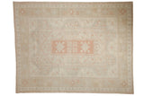 Distressed vintage Oushak carpet, concentric floral medallions in soft ivory and pink grapefruit.