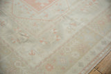 Distressed Oushak rug pile with even wear and ivory, pink grapefruit floral motifs.