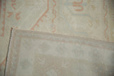 Oushak rug fold revealing distressed ivory pile with even wear and its hand-knotted backing.