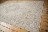 Distressed corner of vintage Sparta carpet, featuring floral palmette border in antique ivory and silver.