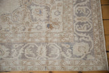Distressed corner of the Vintage Sparta carpet showing antique ivory, silver, and subtle blue palmette border.