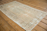 Worn texture and faded geometric pattern of a distressed vintage Oushak rug.