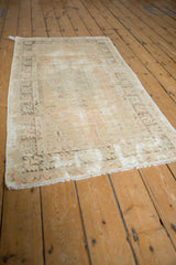 Vintage Oushak rug corner with faded geometric border, distressed pile, and white fringe.