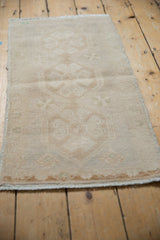 Distressed vintage Oushak rug mat, muted beige tones, faint medallion and abrashes.