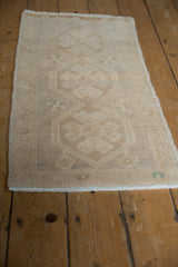 Distressed vintage Oushak rug mat with worn beige pile and faded floral medallion patterns.