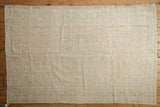 Hand-knotted backing of the distressed Oushak rug, with light beige and subtle green patterns.