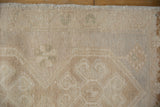 Distressed Oushak rug pile detail, showing even wear, faint foundation, and muted floral design.