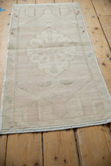 Distressed Oushak runner showcasing muted beige, ivory, and soft green tones in its abrashed field.