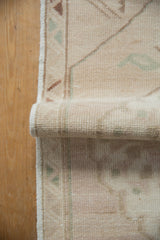 Traditional Oushak rug showing hand-knotted pile, soft distressed tones, and original side selvage.