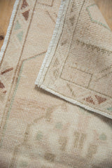 Distressed vintage Oushak runner's worn pile, exposed woven foundation, and intact selvage.