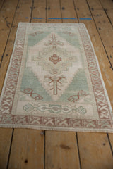Distressed vintage Oushak rug texture with soft ivory and sea foam green tones.