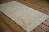 Vintage distressed Oushak runner, textured ivory and beige pile with even wear.
