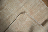 Hand-knotted foundation and tight fringe of a vintage distressed Oushak runner, in light beige tones.