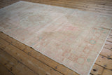 Distressed vintage Oushak rug runner featuring subtle geometric floral motifs and even pile wear.
