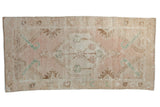 Vintage distressed Turkish Oushak runner with faded dusty rose and ivory central medallion.