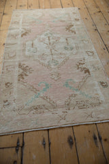 Distressed Oushak rug runner pile with dusty rose, pale aqua serrated leaves, and visible wear.