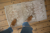 Faded floral patterns and soft abrashes on the distressed vintage Oushak rug.