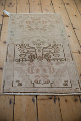 Distressed vintage Oushak rug corner with stepped spandrel, floral motifs, and original selvage.