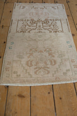 Distressed Oushak rug pile with faded ivory, pale coffee brown floral blossoms, and abrash.