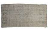 Distressed vintage Oushak runner with subtle floral bouquet in ivory, pale green, and beige.