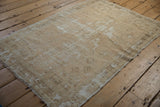 Distressed vintage Oushak rug, highlighting intact side selvage and textured pile.