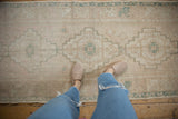 Distressed Oushak runner with faded stepped diamond patterns in sea foam green and blush.