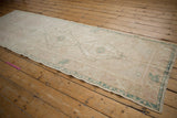 Distressed vintage Oushak runner with faint geometric floral patterns and boteh border in soft tones.
