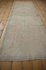 Vintage distressed Oushak rug runner, softened ivory, blush, and seafoam green geometric motifs.