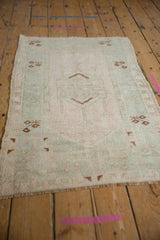 Distressed vintage Melas rug corner, with worn pile, geometric copper brown motifs and fringe.