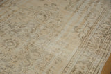 Distressed vintage Oushak rug, showing mostly even wear with faded ivory and brown floral pattern.