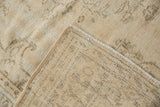 Distressed Oushak rug's hand-knotted foundation and worn pile with intact side cord.