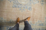 Distressed vintage Oushak carpet, abrashed field with faded blue patterns and blush tones.