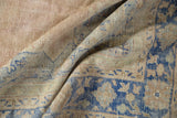 Distressed vintage Oushak rug pile with pale denim blue and dusty blush tones.