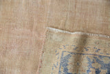 Distressed Oushak carpet's woven foundation with pale blue patterns showing on reverse.