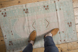 Distressed vintage Turkish Melas rug, blush, pale mint, ivory, with geometric blossoms.