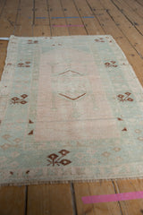 Blush field and mihrab niche with pale mint geometric motifs on a distressed Melas rug.