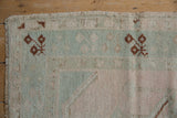 Distressed Melas rug with even wear to knot heads, pale mint green, pink, and brown motifs.