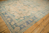 Distressed Oushak carpet corner, dusty denim blue border, mint accents, and pile wear.