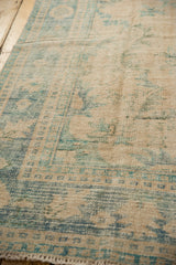 Heavily distressed vintage Oushak carpet texture with faded antique ivory and dusty denim blue patterns.