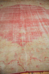 Worn cherry red field and antique ivory Samovar floral border on a Vintage Oushak carpet.