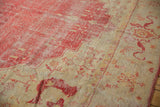 Oushak carpet detail: cherry red field to antique ivory border, with stepped contour, vinery, and softened pile.