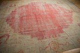 Stepped ivory corner spandrel with vinery and cherry red field of a Vintage Oushak rug.