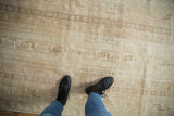 Faded agricultural motif on distressed vintage Oushak rug in soft ivory and beige.