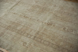 Distressed pile texture of a vintage Oushak rug, showing soft beige and ivory patterns.