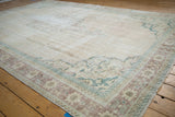 Vintage distressed Oushak rug corner detailing muted ivory, pale chestnut, and ocean green borders.